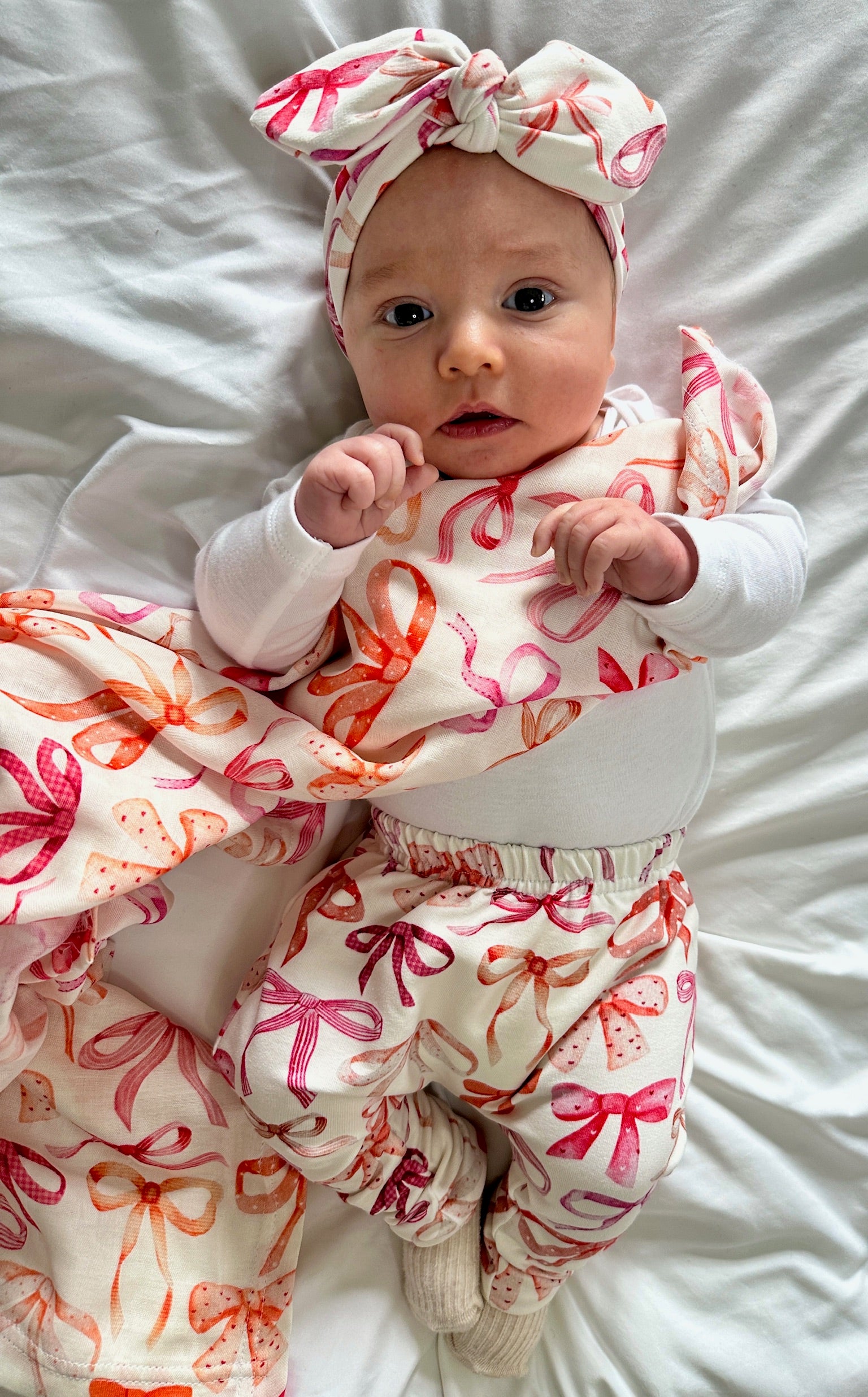 Baby wearing pink and red bow leggings with matching head band