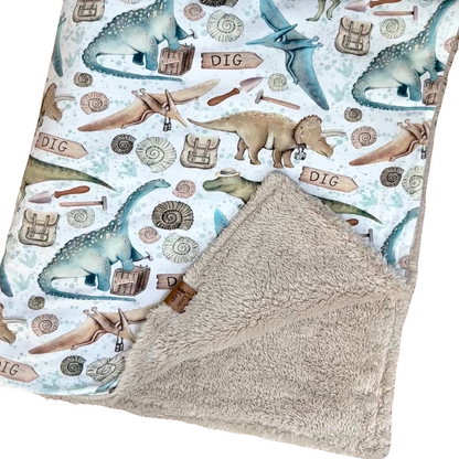 Fleece baby blanket featuring a dinosaur pattern